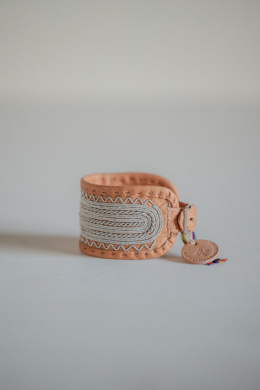 MARIA RUDMAN SPECIAL WATCH in undyed tan reindeer leather, front view showing Sámi pewter embroidery and a round leather tag.